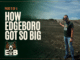 How Edgeboro Got So Big A man in sunglasses and an Eyes on EB t-shirt stands on the bare graded surface of the Edgeboro Road landfill under a blue sky, gesturing back over his shoulder toward the working face, with heavy equipment and a landfill ridge behind him. Overlaid title card reads: Eyes on EB, Part 2 of 4, How Edgeboro Got So Big.